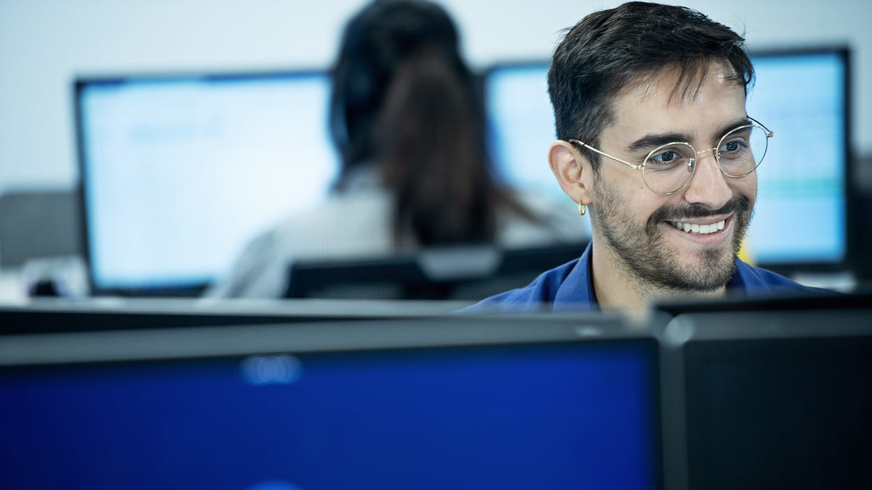  A person wearing a DSV shirt works at a computer.