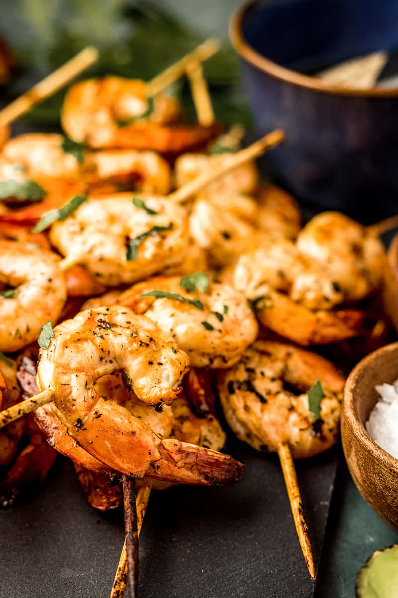 A close up view of smoked shrimp skewers next to Whole30 complaint marinade