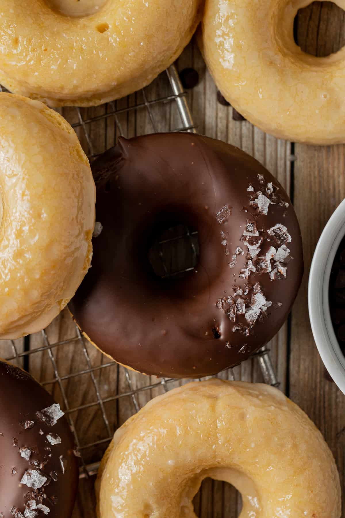 An overview shot of donuts including glaed donuts and a chocolte glaze donut with sea salt.