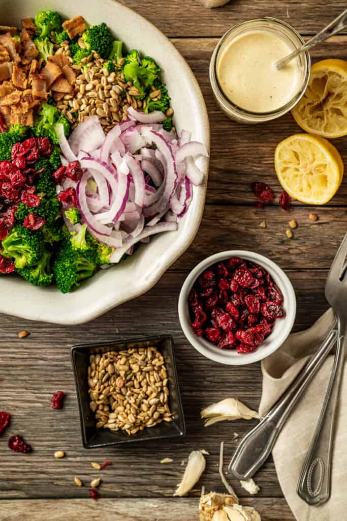 An overview shot of paleo broccoli salad with bacon on a wood background