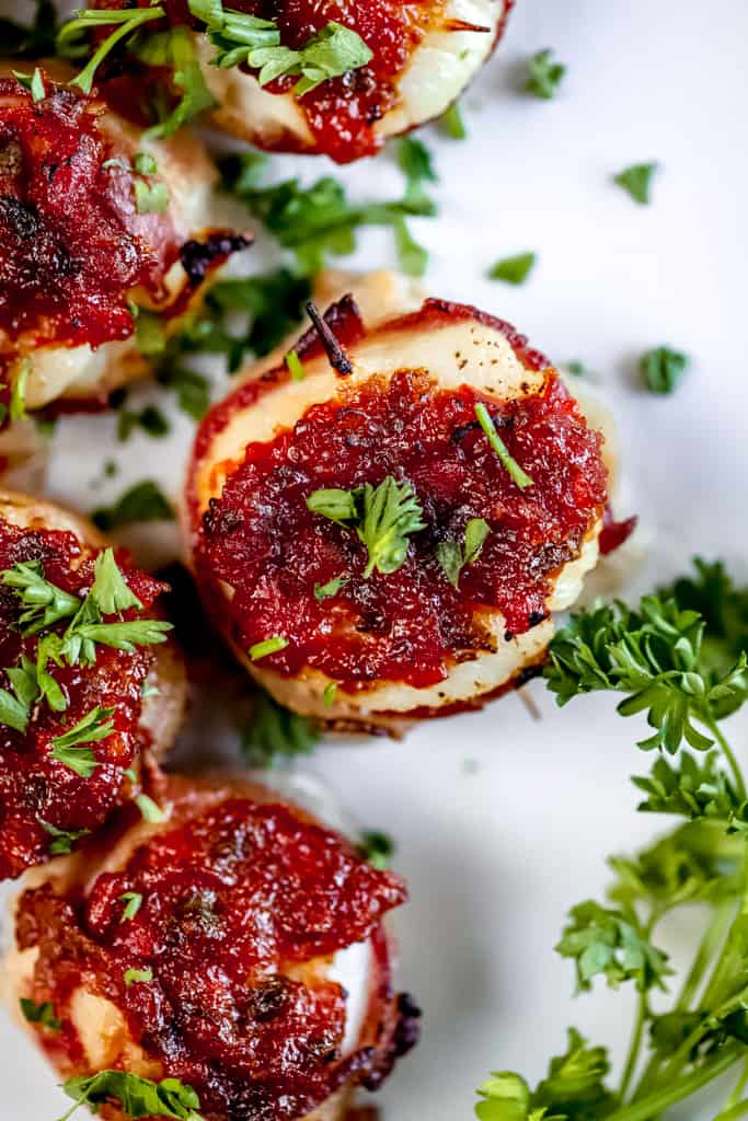 An overview of scallops wrapped in bacon topped with pepper relish