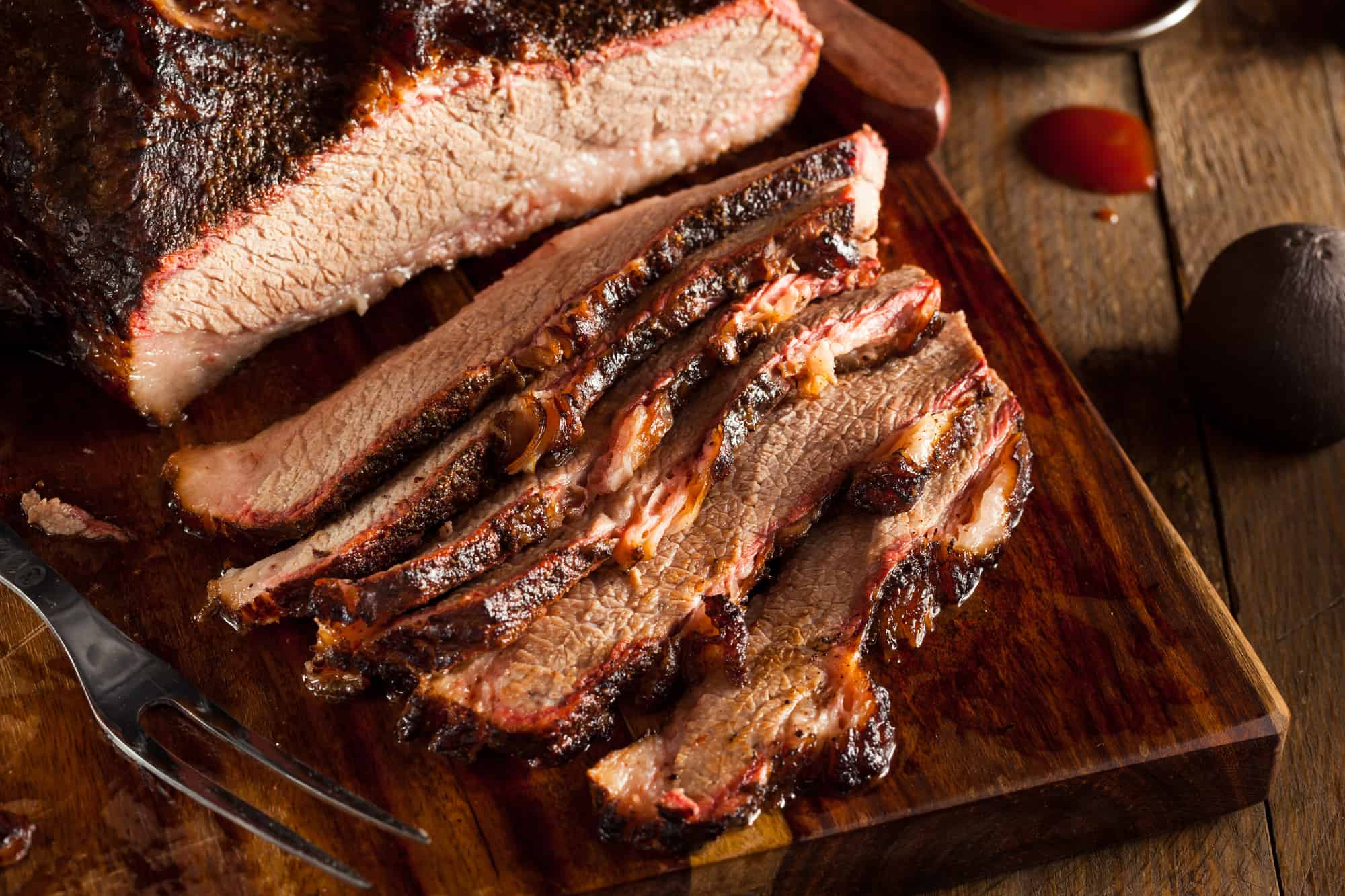 Sliced brisket on a wood cutting board.