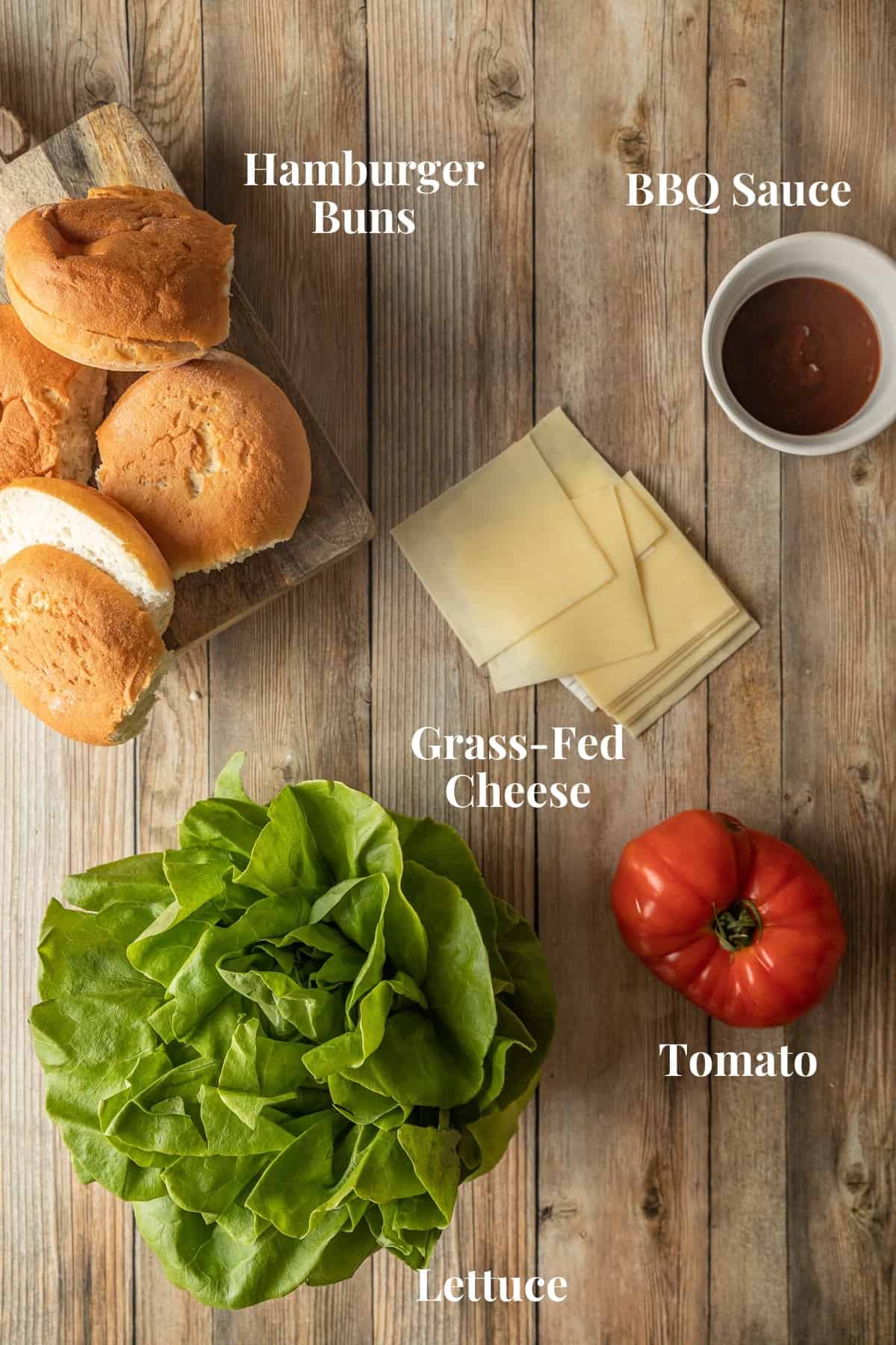 An overview shot of various smash burger toppings on a wood background.