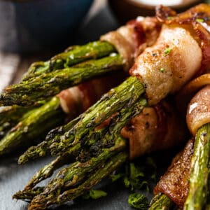 A close up view of bacon wrapped asparagus bundles