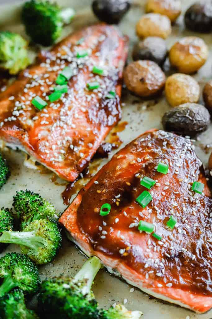 A sheet pan of teriyaki salmon, roasted potatoes, and roasted broccoli.
