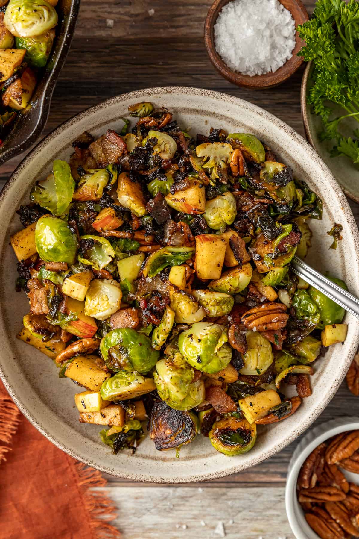 An overview shot of a bowl of brussel sprouts with apples and pecans topped with balsamic glaze.