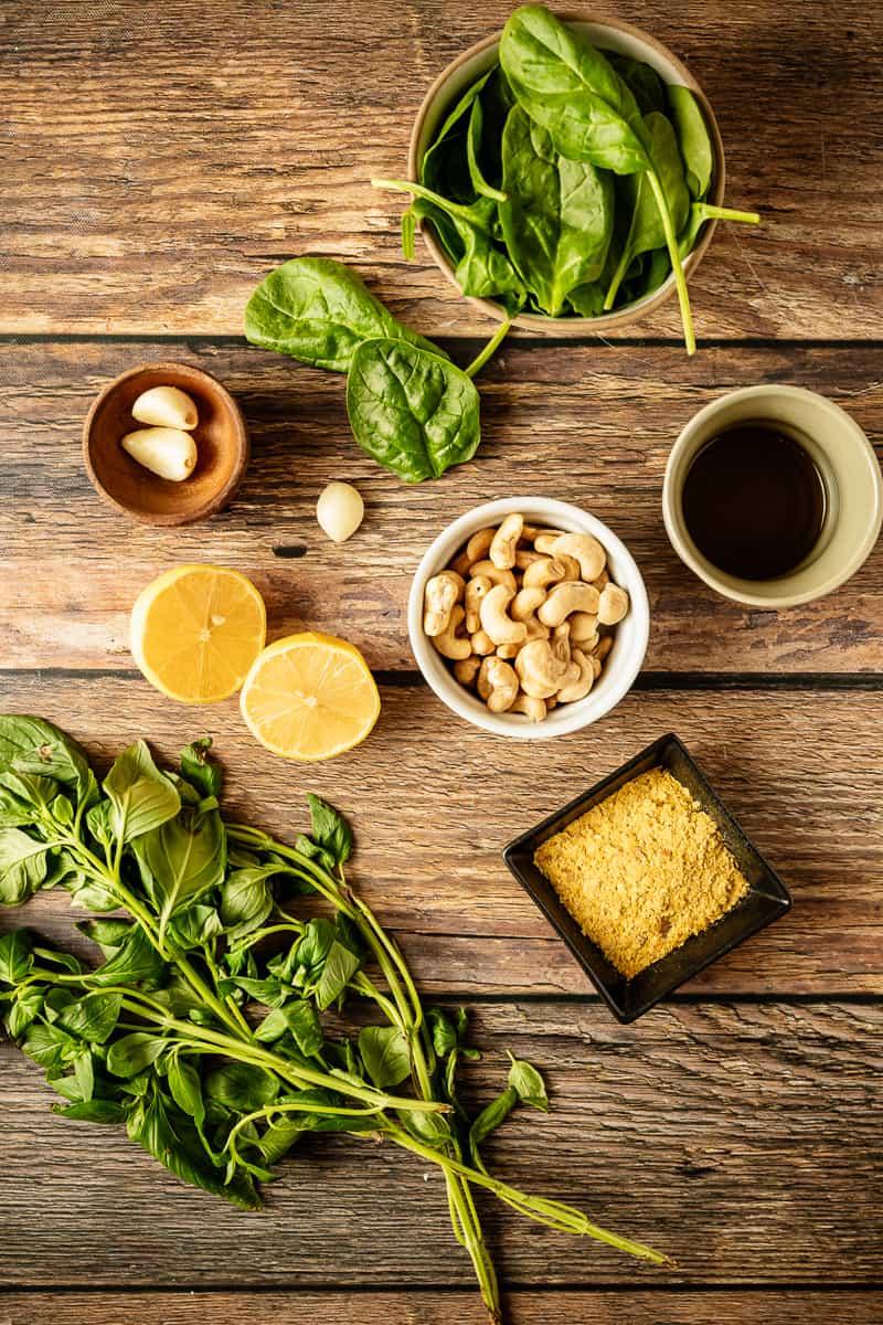 An overhead shot of the ingrdients needed to make pesto on a wooden background